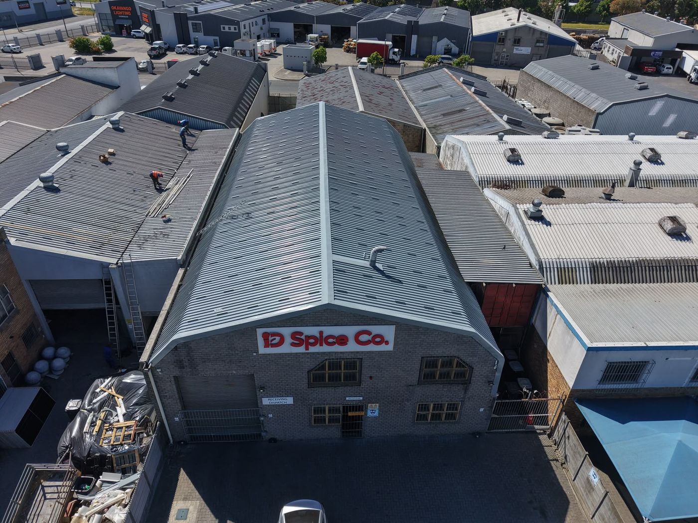 Factory roof coated in grey among older roofs